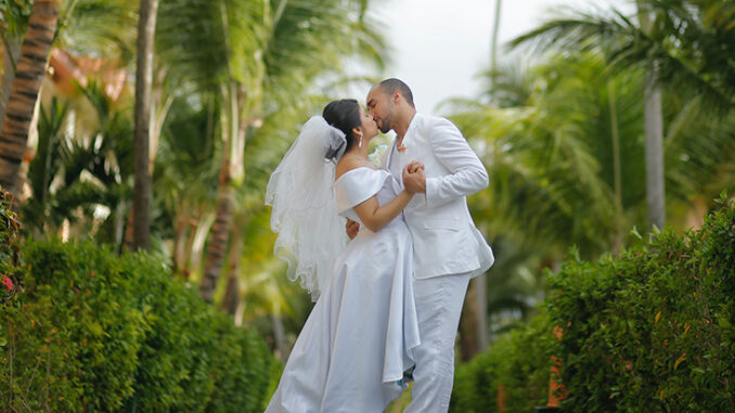a man and woman kiss as newly weds