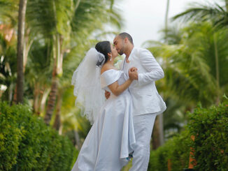 a man and woman kiss as newly weds